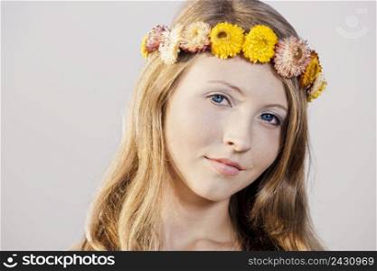 Beautiful young woman in a meadow wearing a crown of flowers