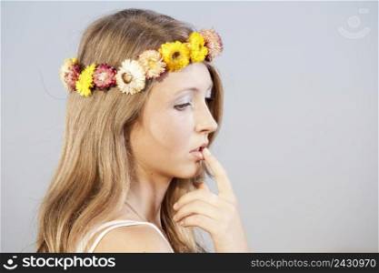 Beautiful young woman in a meadow wearing a crown of flowers