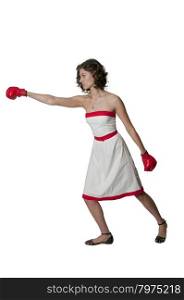 Beautiful young woman in a red and white dress wearing a pair of boxing gloves