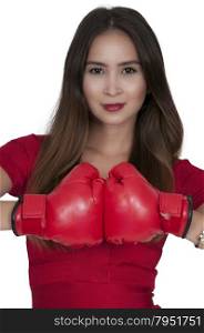 Beautiful young woman in a red dress wearing a pair of boxing gloves