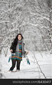 Beautiful young woman in a sweater on a winter walk in a forest. Looking At Camera