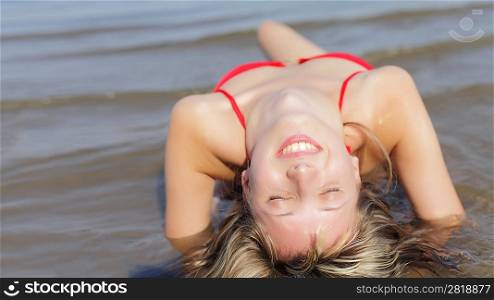 beautiful young woman in black bikini in water closed eyes