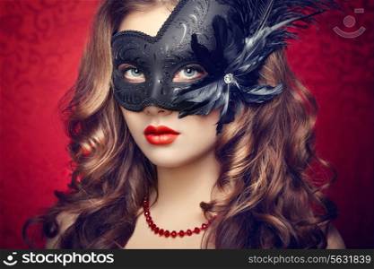 Beautiful young woman in black mysterious Venetian mask. Fashion photo