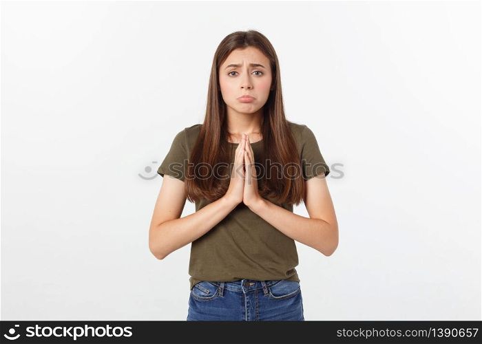 Beautiful young woman in casual clothes holding hands together and praying, isolated on white. Beautiful young woman in casual clothes holding hands together and praying, isolated on white.