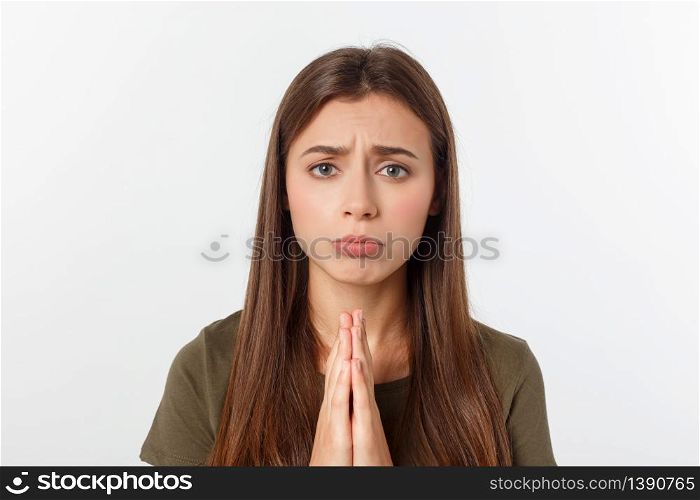 Beautiful young woman in casual clothes holding hands together and praying, isolated on white. Beautiful young woman in casual clothes holding hands together and praying, isolated on white.