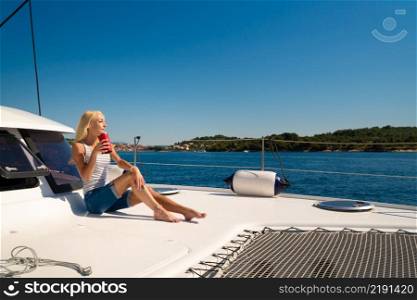 beautiful young woman in casual wear drinking tea of coffee on a yacht front. Croatia. Europe. beautiful young woman in casual wear drinking tea of coffee on a yacht front