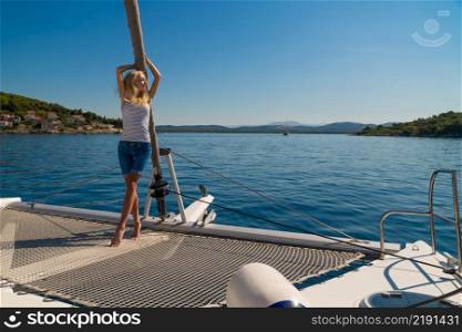 beautiful young woman in casual wear standing on a yacht fore. Croatia. Europe. beautiful young woman in casual wear standing on a yacht fore