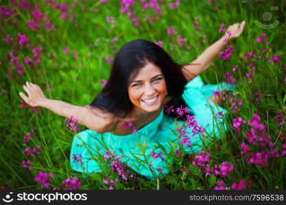 Beautiful young woman in dress on summer flower field. Woman on summer flower field