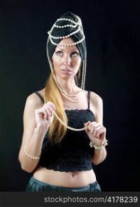 beautiful young woman in east turban, with pearl beads on dark background
