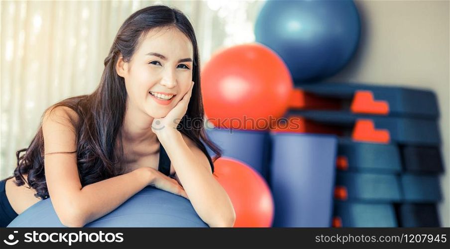 Beautiful young woman in fitness center doing pilates exercise with fitness ball. Healthy lifestyle concept.. Young woman pilates exercise with fitness ball.