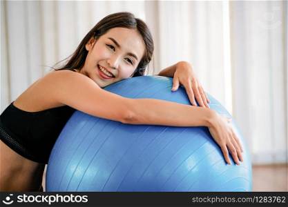 Beautiful young woman in fitness center doing pilates exercise with fitness ball. Healthy lifestyle concept.. Young woman pilates exercise with fitness ball.