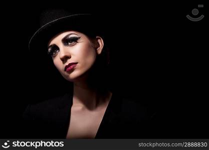 Beautiful young woman in hat on the black background