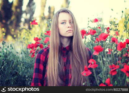 Beautiful young woman in poppy field. Enjoy nature. Photo toned style instagram filters