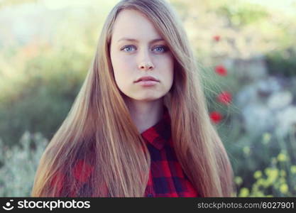 Beautiful young woman in poppy field. Enjoy nature. Photo toned style instagram filters