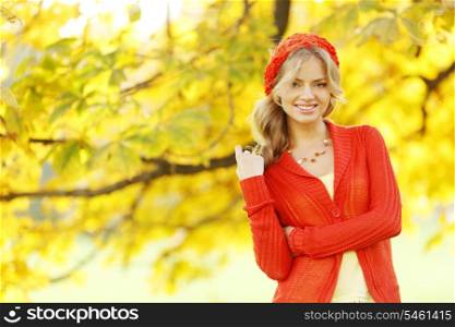 Beautiful young woman in red clothes in autrumn park