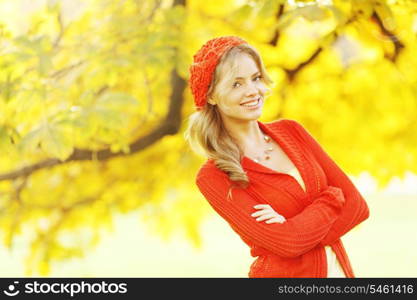 Beautiful young woman in red clothes in autrumn park