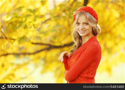 Beautiful young woman in red clothes in autrumn park