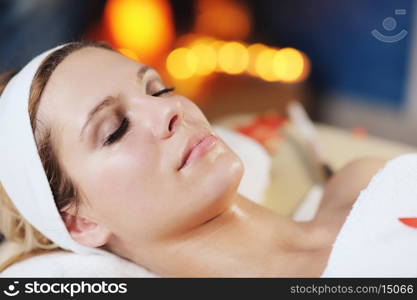 Beautiful young woman in spaand wellness. Face back and stone massage