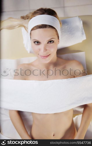 Beautiful young woman in spaand wellness. Face back and stone massage