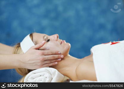 Beautiful young woman in spaand wellness. Face back and stone massage