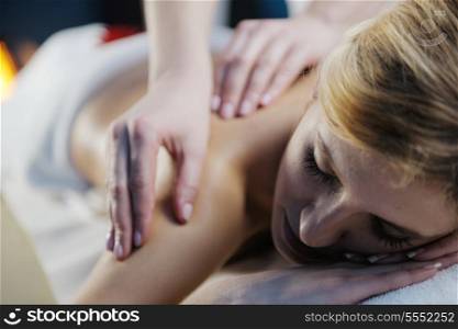 Beautiful young woman in spaand wellness. Face back and stone massage