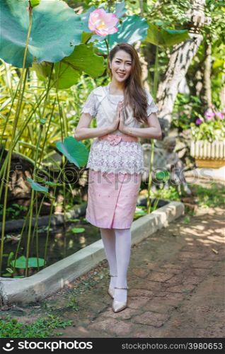 beautiful young woman in Thai traditional dress is pay respect