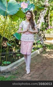beautiful young woman in Thai traditional dress is pay respect