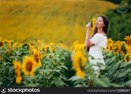 beautiful young Woman in the field of sunflowers. girl with long brunette hair inhales aroma of wild flower. Summer time. selective focus.. beautiful young Woman in the field of sunflowers. girl with long brunette hair inhales aroma of wild flower. Summer time. selective focus