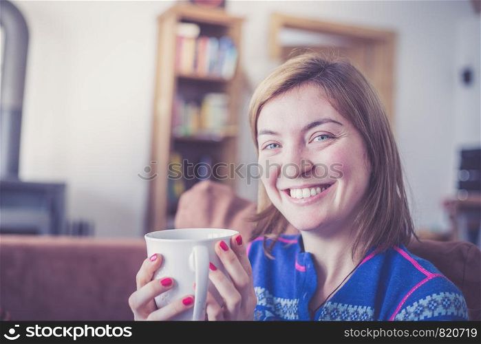 Beautiful young woman is enjoying a cup of tea