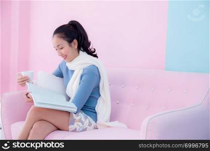 Beautiful young woman is reading book and holding a cup of coffee with in room retro pastel style.