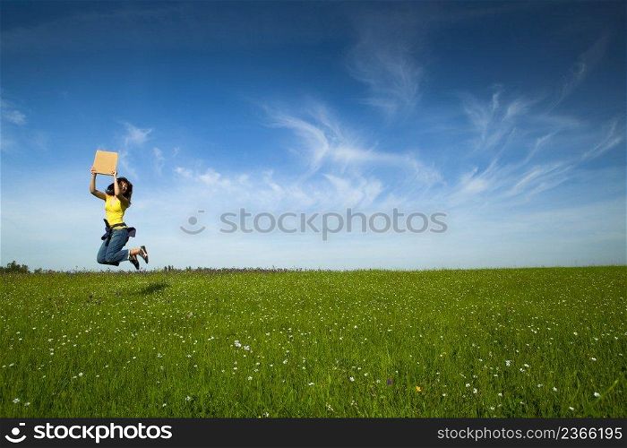 Beautiful young woman jumping and holding a blank paper card