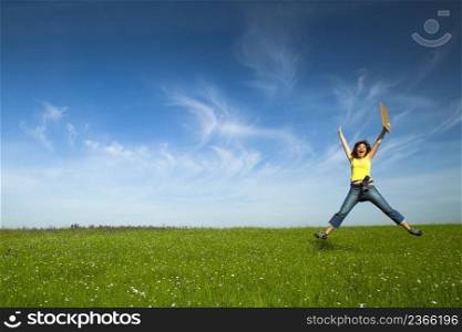 Beautiful young woman jumping and holding a blank paper card