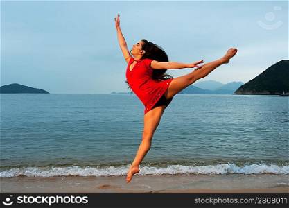 Beautiful young woman jumping in the sea