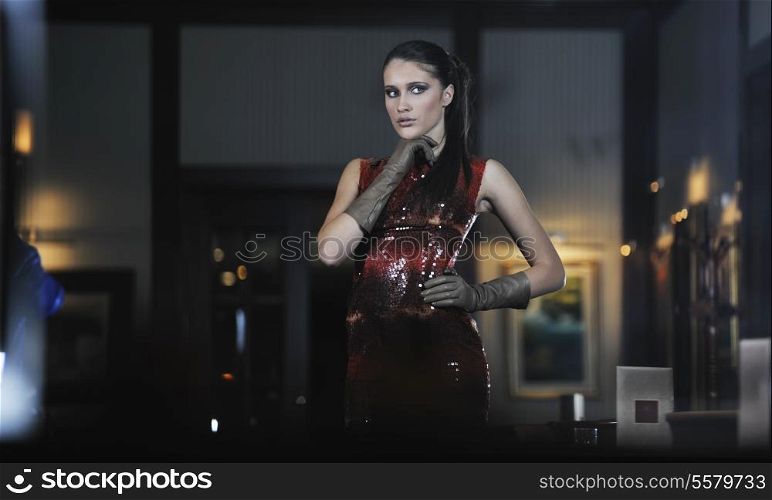beautiful young woman lady in fashion dress posing in restaurant or bar at night