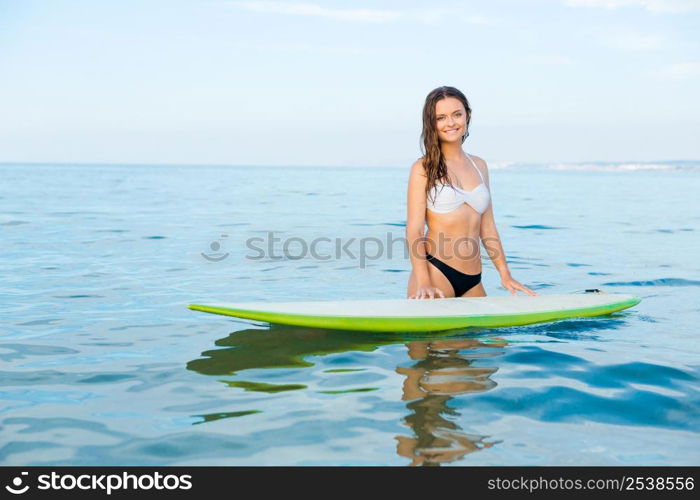 Beautiful young woman learning to surf