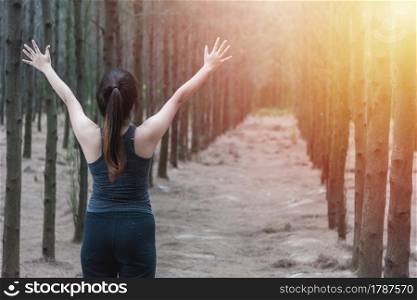 Beautiful young woman lifestyle enjoying fresh air happy relaxing in green forest park