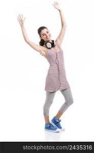 Beautiful young woman listen music with arms up, isolated over a white background