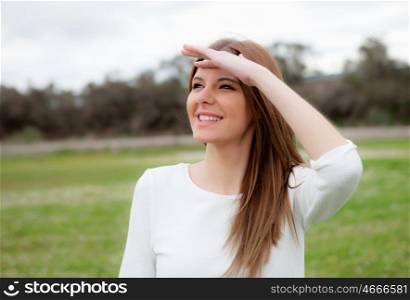 Beautiful young woman looking at side in the meadow