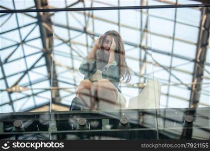 Beautiful young woman looking through window at airport