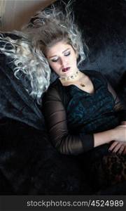 Beautiful young woman lying on a velvet throw