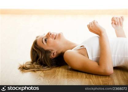 Beautiful young woman lying on floor and smiling
