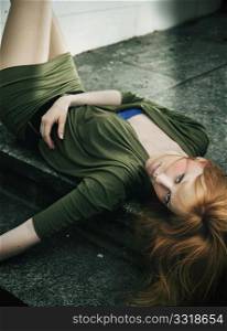 Beautiful young woman lying on ground