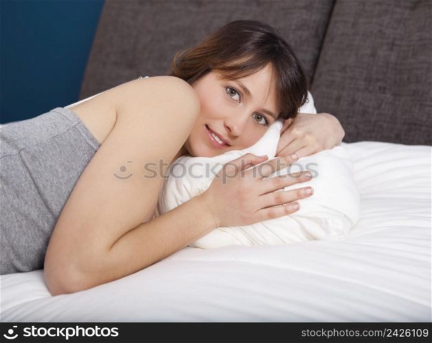Beautiful young woman lying on the bed