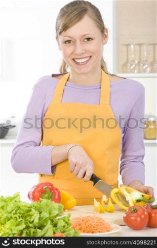 Beautiful young woman making vegetarian vegetable salad