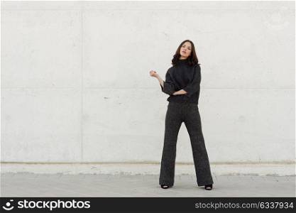 Beautiful young woman, model of fashion, in urban background