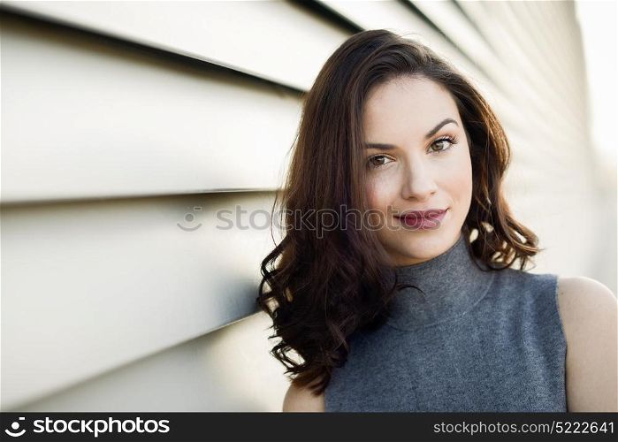 Beautiful young woman, model of fashion, smiling in urban background