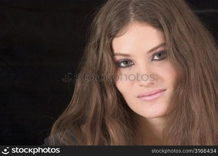 Beautiful young woman on black background