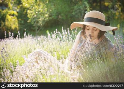 Beautiful young woman on lavender field. Sunset. Attractive young female outdoors.