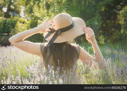 Beautiful young woman on lavender field. Sunset. Attractive young female outdoors.