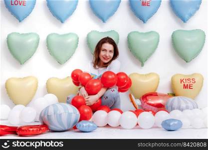 beautiful young woman on many colorful heart balloons background. smiles,funny Valentine s Day birthday party. beautiful young woman on many colorful heart balloons background. smiles,funny Valentine s Day birthday party.